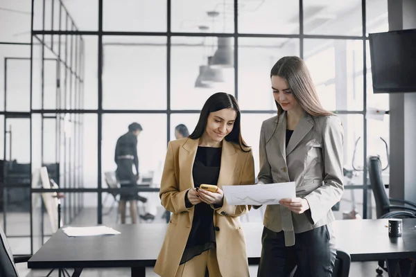 Multi-etnische collega 's uit het bedrijfsleven bekijken papieren documenten terwijl ze in een modern kantoor staan — Stockfoto