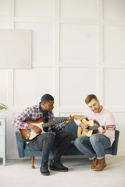 Hombre africano y hombre caucásico tocando la guitarra — Foto de Stock