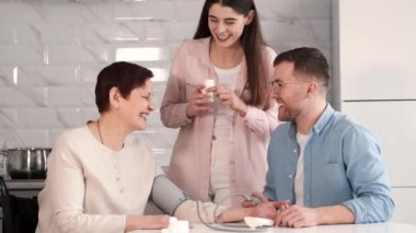 Engelli anneye yardım eden çift tansiyonunu ölçüyor