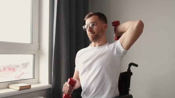 Joven en silla de ruedas haciendo ejercicios en interiores — Vídeos de Stock