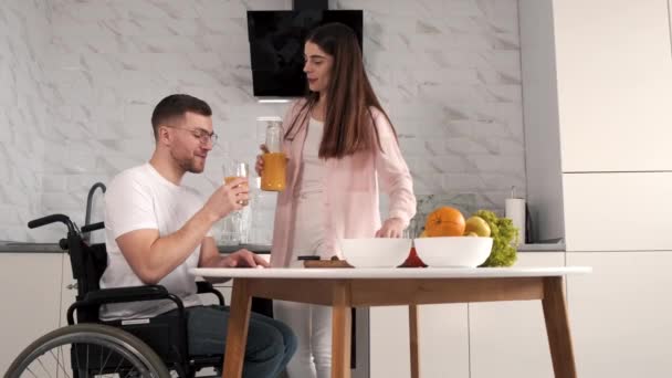 Femme encourager mari handicapé assis en fauteuil roulant à la table de cuisine — Video