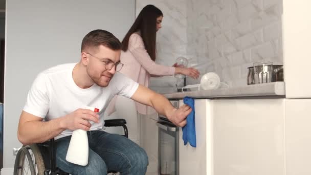 Jeune homme handicapé sur cuisinière de nettoyage en fauteuil roulant — Video