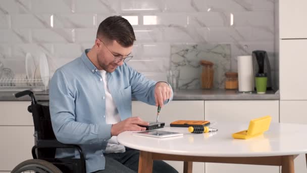 Jonge gehandicapte man repareert moederbord in keuken — Stockvideo