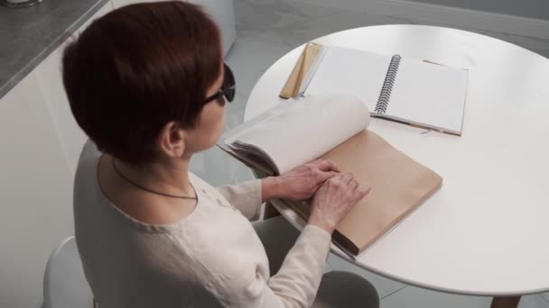 Cieco donna matura lettura braille libro a casa — Video Stock