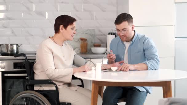 障害のある母親が血圧を測定するのを助けるカップル — ストック動画