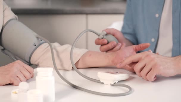 Coppia che aiuta la madre disabile a misurare la pressione sanguigna — Video Stock