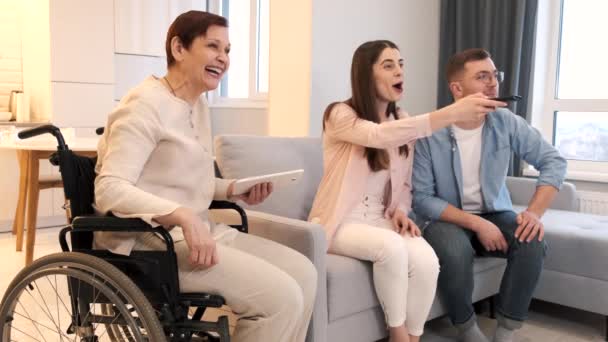 車椅子の女性は介護者とテレビを見る — ストック動画