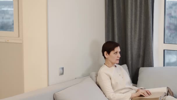 Wanita dewasa membaca buku braille di sofa — Stok Video