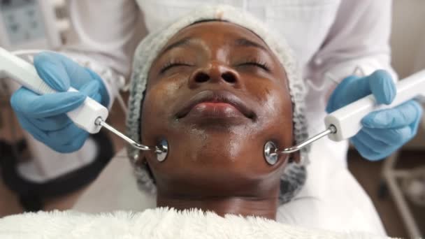 Косметолог робить процедуру очищення обличчя за допомогою обладнання — стокове відео