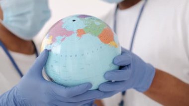 Dünya 'yı tutan maske takan çeşitli gönüllülerden oluşan bir grup.