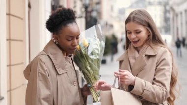 Alışveriş çantalı iki genç kadın ne aldıklarını kontrol ediyor.