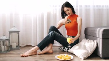 Flor 'da portakal suyuyla oturan genç bir kadın.