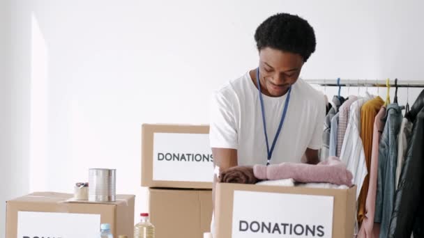 Volunteers wearing masks sorting clothes donations during pandemic — Stock Video