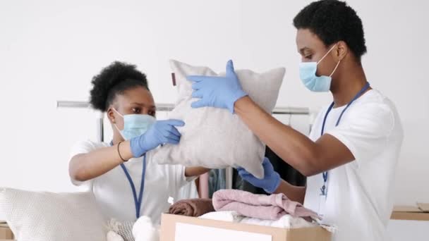 Bénévoles portant des masques triant les dons de vêtements pendant la pandémie — Video