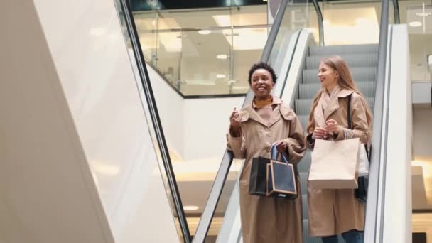 Hermosas chicas están sosteniendo bolsas de compras y compras en el centro comercial — Vídeos de Stock