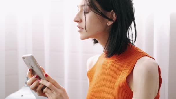 Mujer joven sentada en la flor con jugo de naranja — Vídeos de Stock