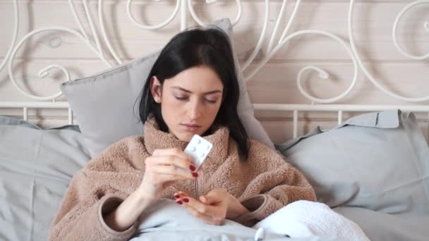 Mulher doente deitado na cama e tomando em comprimidos — Vídeo de Stock