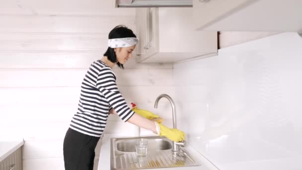 Eldivenli kadın mutfak odasında bulaşık yıkıyor. — Stok video