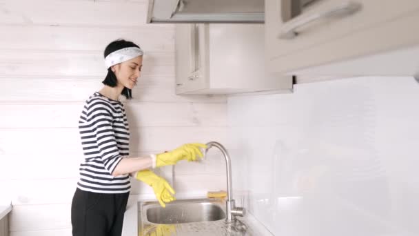 Eldivenli kadın mutfak odasında bulaşık yıkıyor. — Stok video