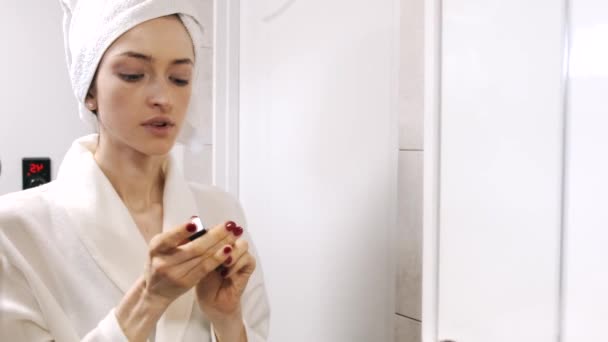 Jovem atraente com toalha na cabeça aplicar maquiagem — Vídeo de Stock