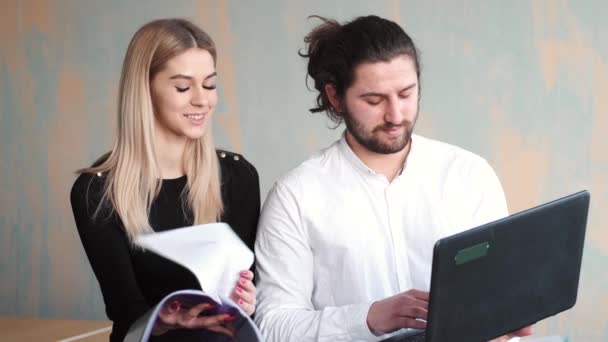 Чоловік і жінка погоджуються працювати з паперами в офісі — стокове відео