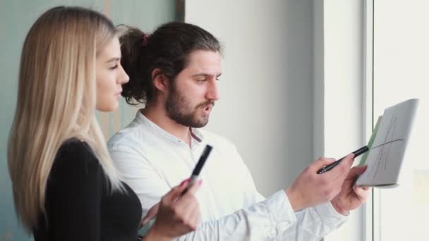 Employés de bureau masculins et féminins analysant le diagramme sur l'image — Video