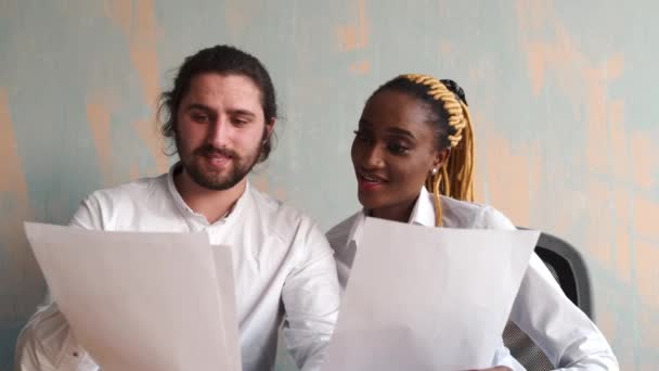 아름다운 아프리카 사업가와 코카서스 남자가 노트북을 가지고 일하는 모습 — 비디오