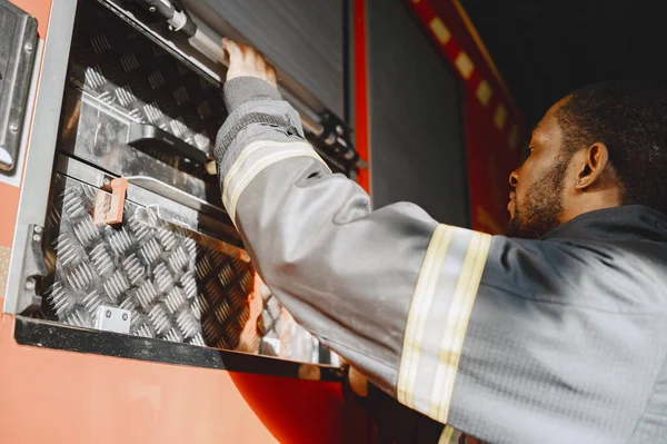 Ritratto di un vigile del fuoco in piedi davanti a un motore antincendio — Foto Stock