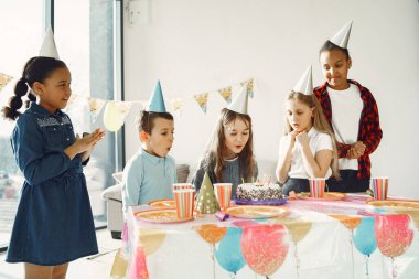 Bir grup çocuk doğum gününü kutluyor.