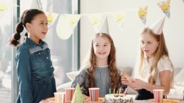 Bir grup çocuk dekore edilmiş evde doğum günü partisi veriyor.