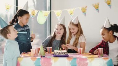 Bir grup çocuk dekore edilmiş evde doğum günü partisi veriyor.