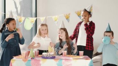 Bir grup çocuk dekore edilmiş evde doğum günü partisi veriyor.