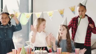 Bir grup çocuk dekore edilmiş evde doğum günü partisi veriyor.