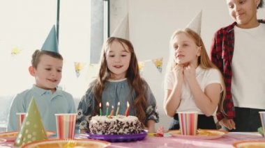 Bir grup çocuk dekore edilmiş evde doğum günü partisi veriyor.