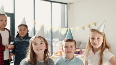 Bir grup çocuk dekore edilmiş evde doğum günü partisi veriyor.