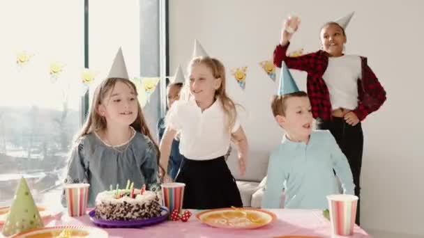 Grupo de niños celebrando fiesta de cumpleaños en casa decorada — Vídeo de stock