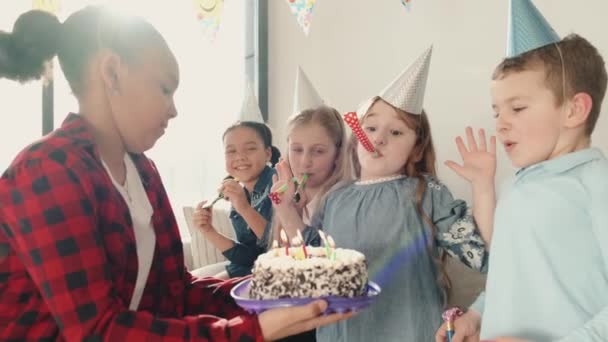 Группа детей, празднующих день рождения в украшенном доме — стоковое видео
