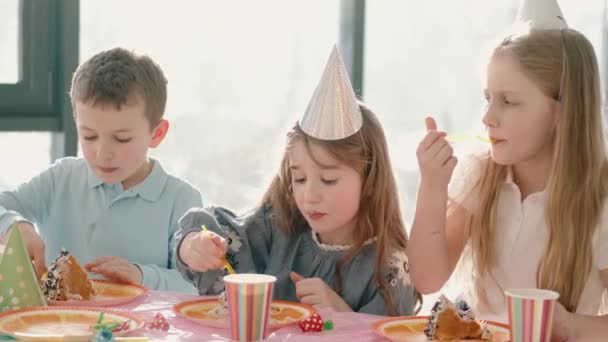 Grupa dzieci jedzących na urodzinach w zabawnych dekoracjach — Wideo stockowe