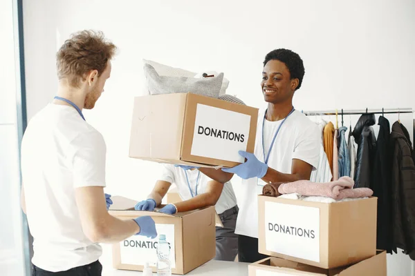 Volunteers sort through boxes with help