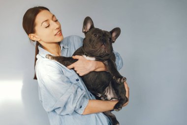 Mavi gömlekli, siyah bulldoglu zarif bir kadın.