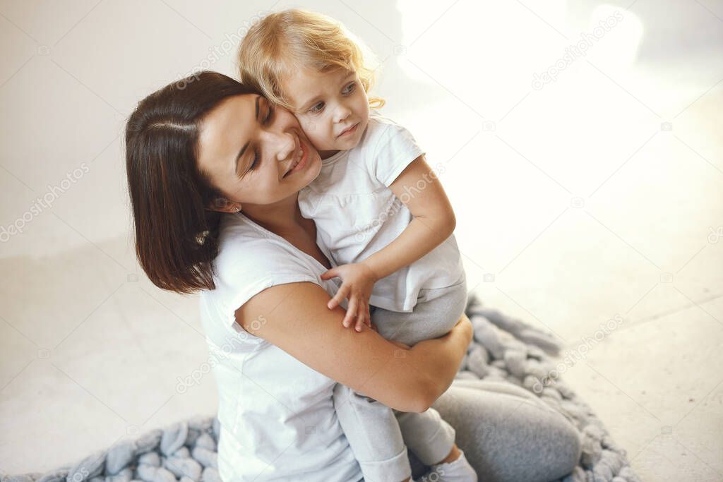 Mother and little daughter have fun on a blue background