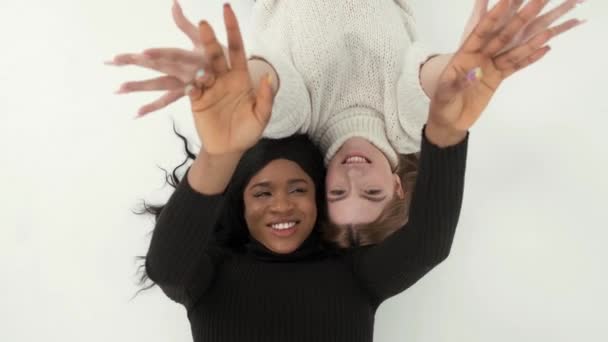 Dos mulri raciales amigas posando y divirtiéndose en el estudio — Vídeos de Stock
