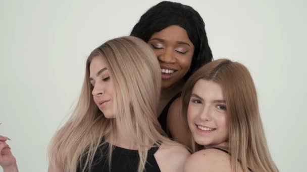 Gruppe multiethnischer Freundinnen posiert und macht sich im weißen Studio lustig — Stockvideo