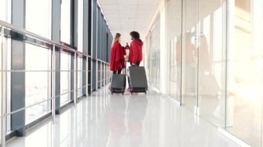 Bavullu çift havaalanında kahve içiyor.