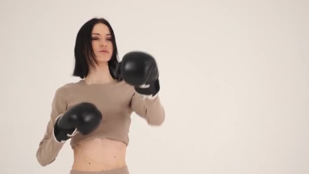 Giovane donna che pratica la boxe su sfondo bianco — Video Stock