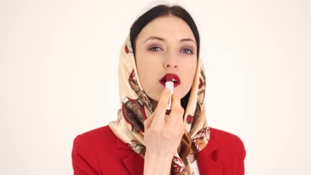 Femme en châle appliquer res rouge à lèvres en studio blanc — Video