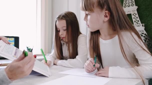 Lärare undervisar två skolflickor i klassrummet — Stockvideo