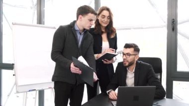 Ofiste bir proje üzerinde çalışan üç iş arkadaşı.