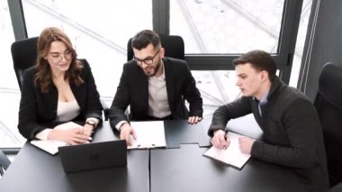 Ofiste bir proje üzerinde çalışan üç iş arkadaşı.