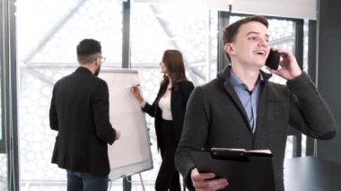 Ofiste bir proje üzerinde çalışan üç iş arkadaşı.